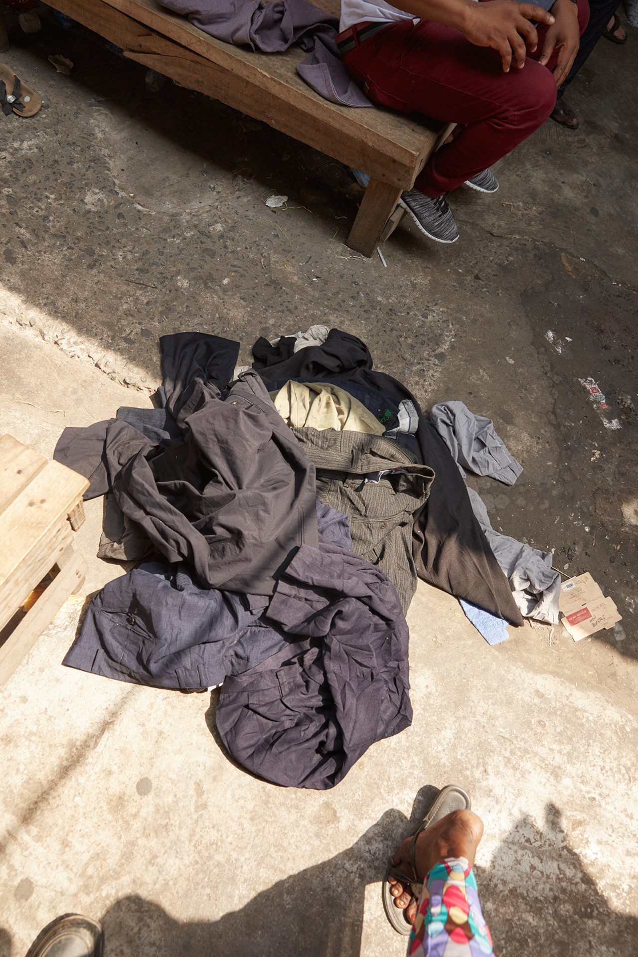 Second hand clothing on the floor in Kantamanto market in Accra Ghana by Charlie Engman