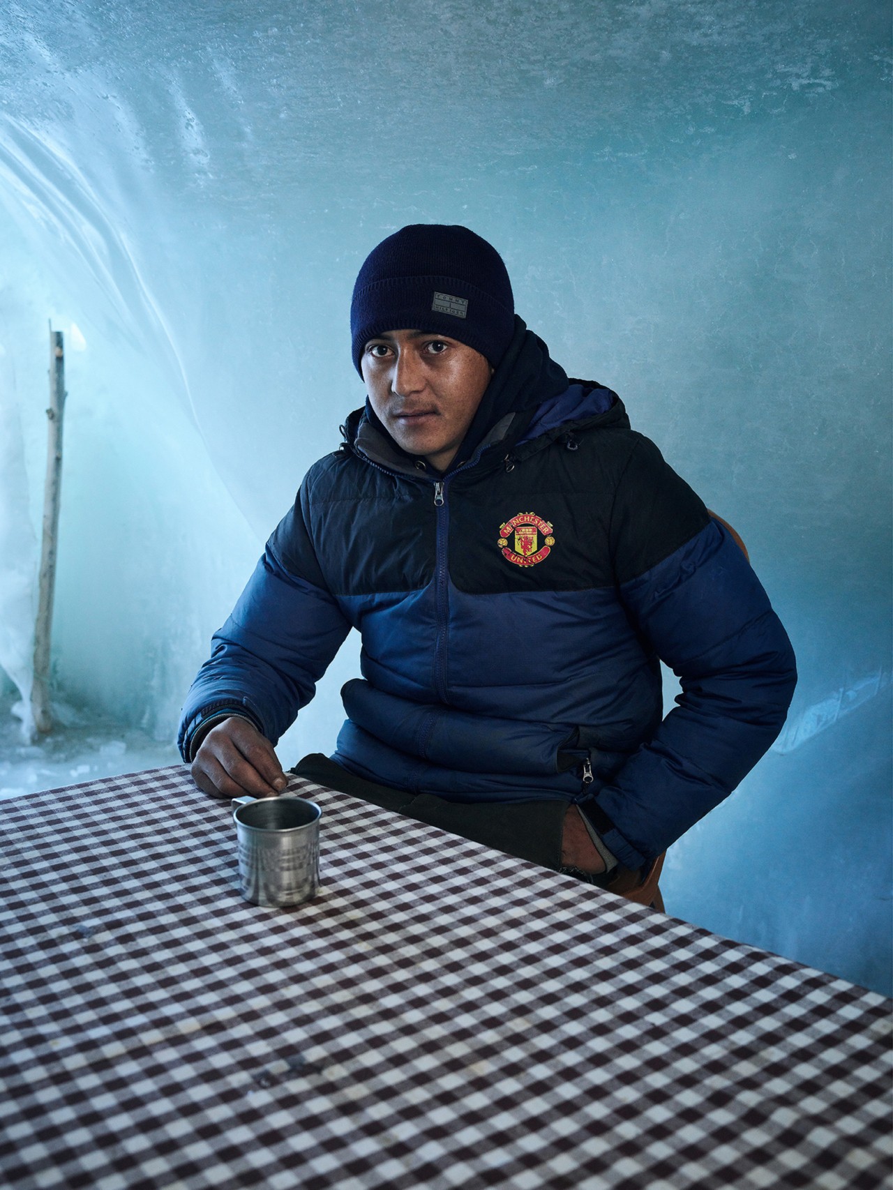 A man drinks a beverage inside an ice stupa in Ladakh India by Greg White