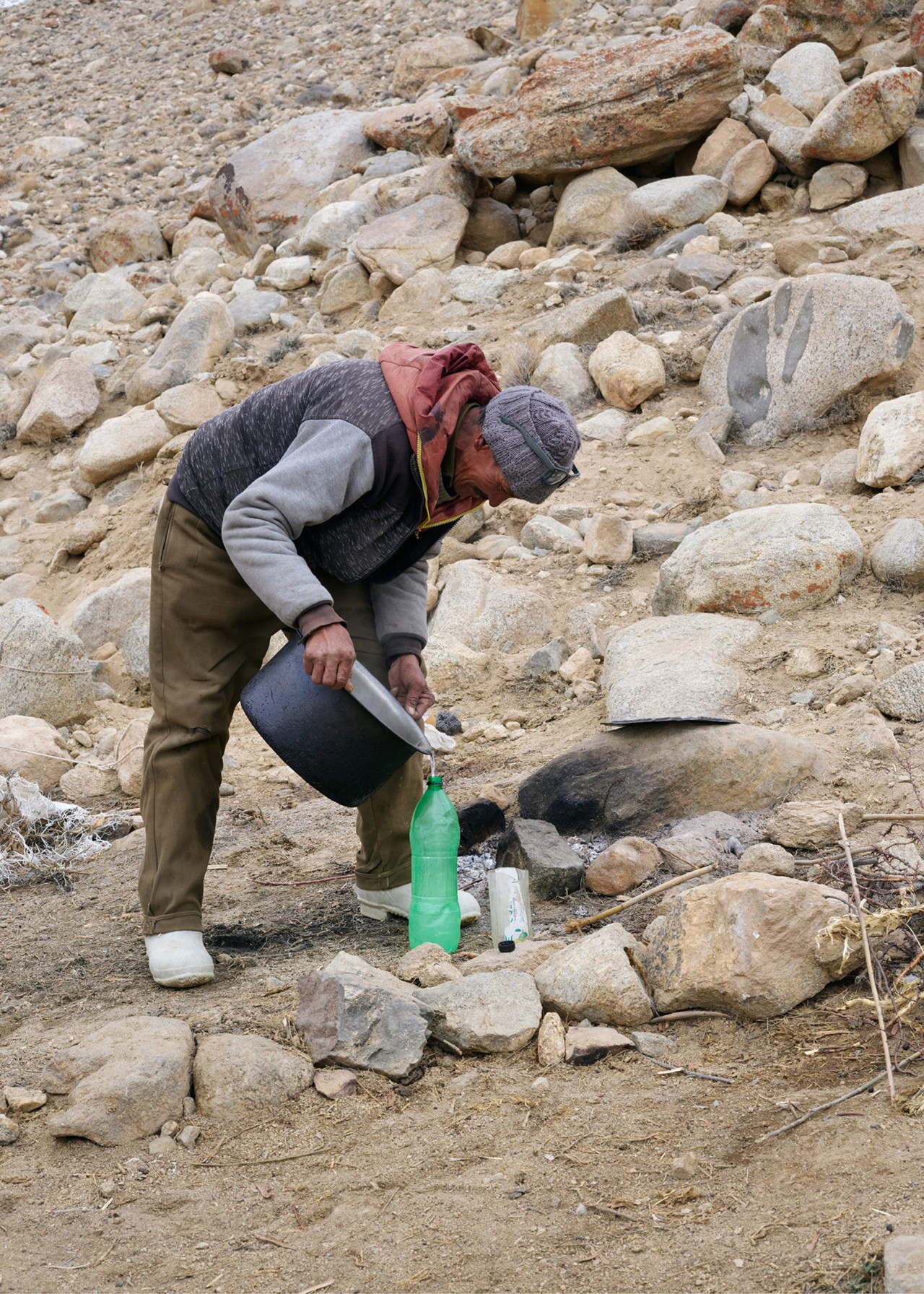 Villager harvests water from an ice stupa in Ladakh India by Greg White