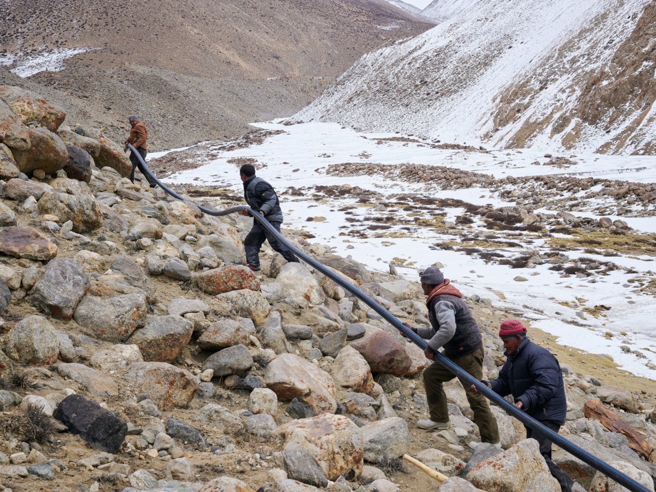 Volunteers lay pipes that carry glacial runoff in Ladakh India by Greg White