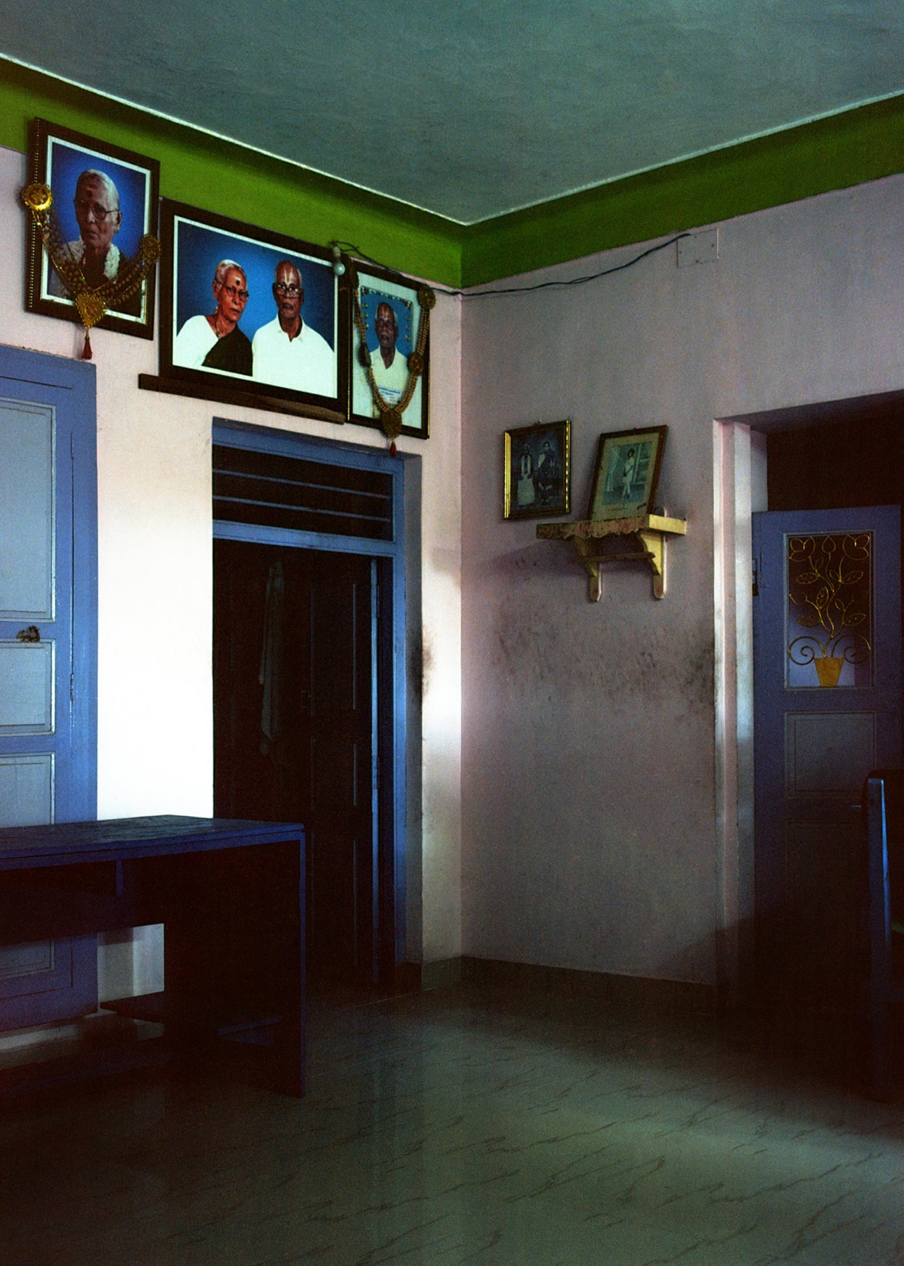 A room with portraits hanging on the wall in India by Ashish Shah