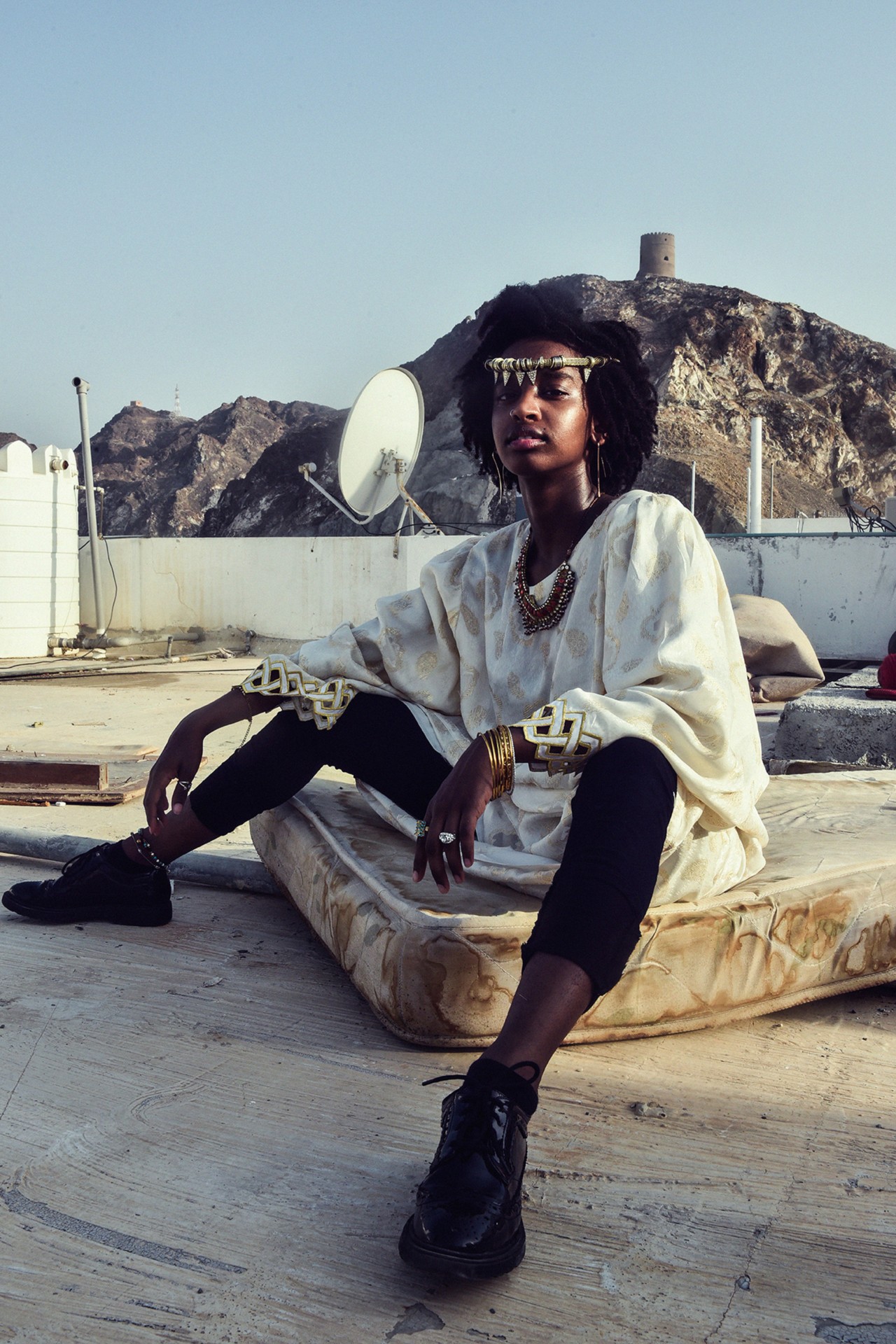 A model wears local fashion on a rooftop in Oman by Ali Al Sharji