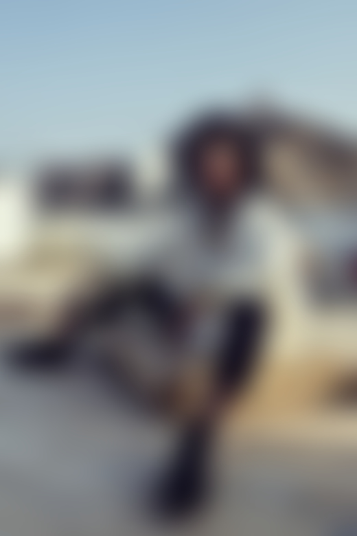 A model wears local fashion on a rooftop in Oman by Ali Al Sharji