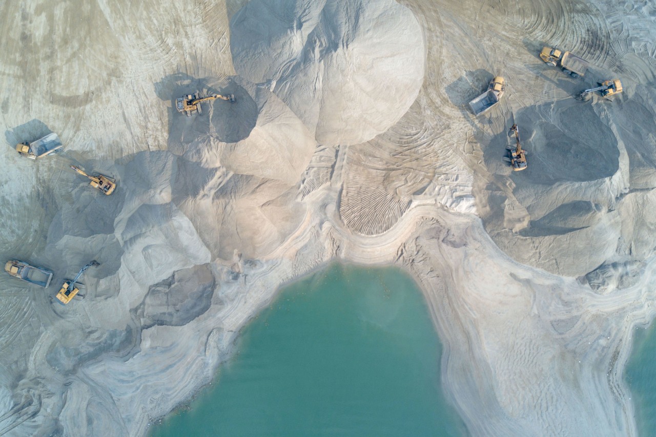 Aerial view of tractors ploughing through piles of sand at a development in Malaysia by Sim Chi Yin