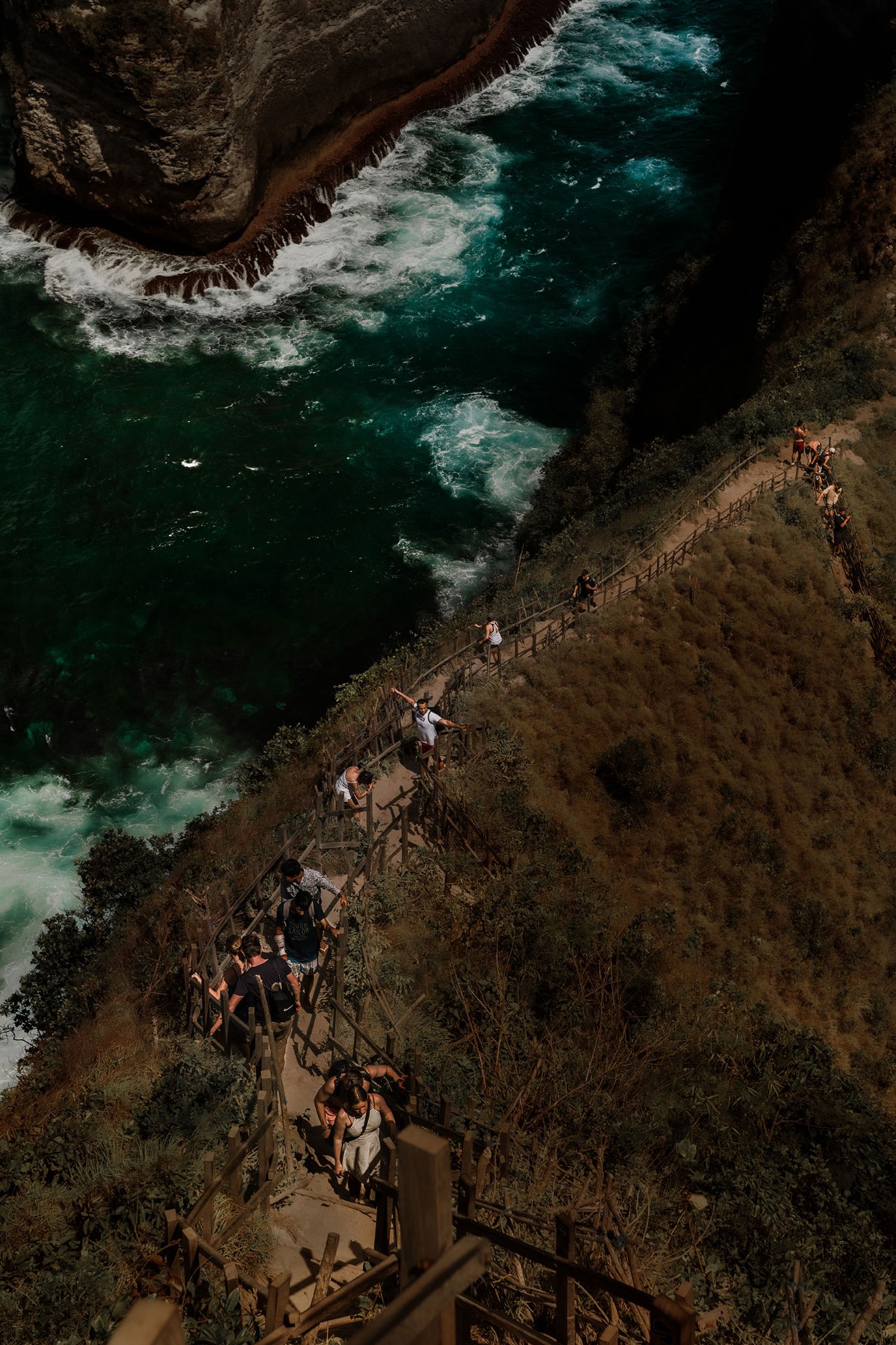 Tourists walking on cliff in Nusa Penuda Indonesia by Rishabh Malik