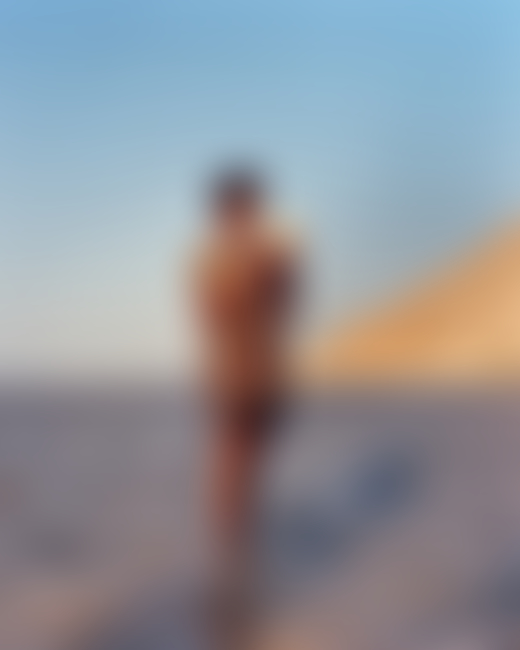 A man stands in the water and holds a blowfish in Socotra Yemen by Jamie Hawkesworth
