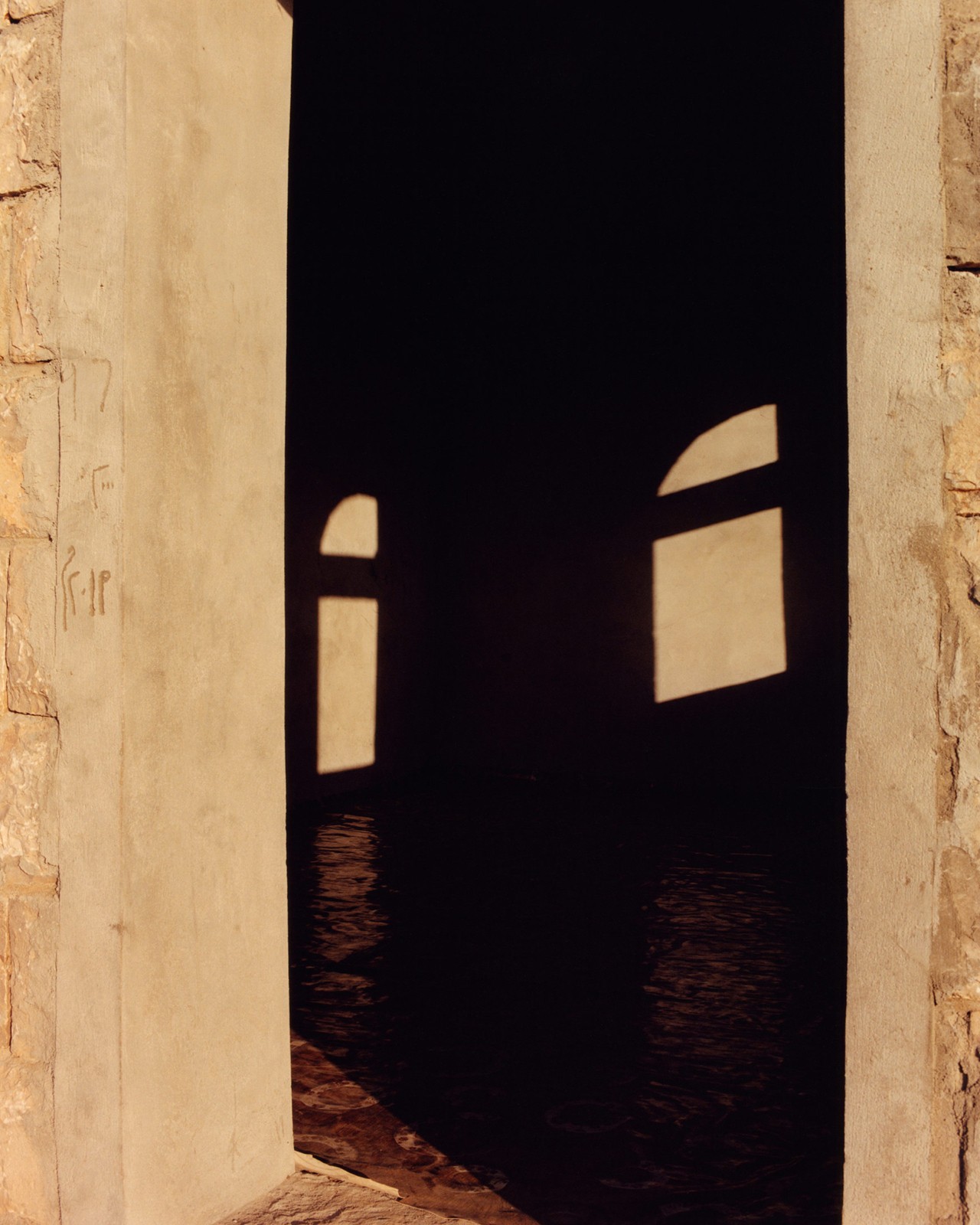 Light creates shadows as it shines through the window of a building in Socotra Yemen by Jamie Hawkesworth