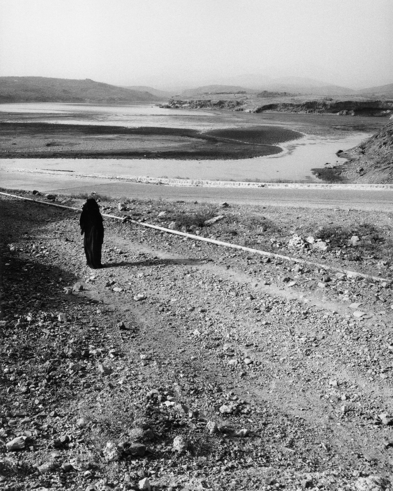 A woman walks along a desert road in Socotra Yemen by Jamie Hawkesworth