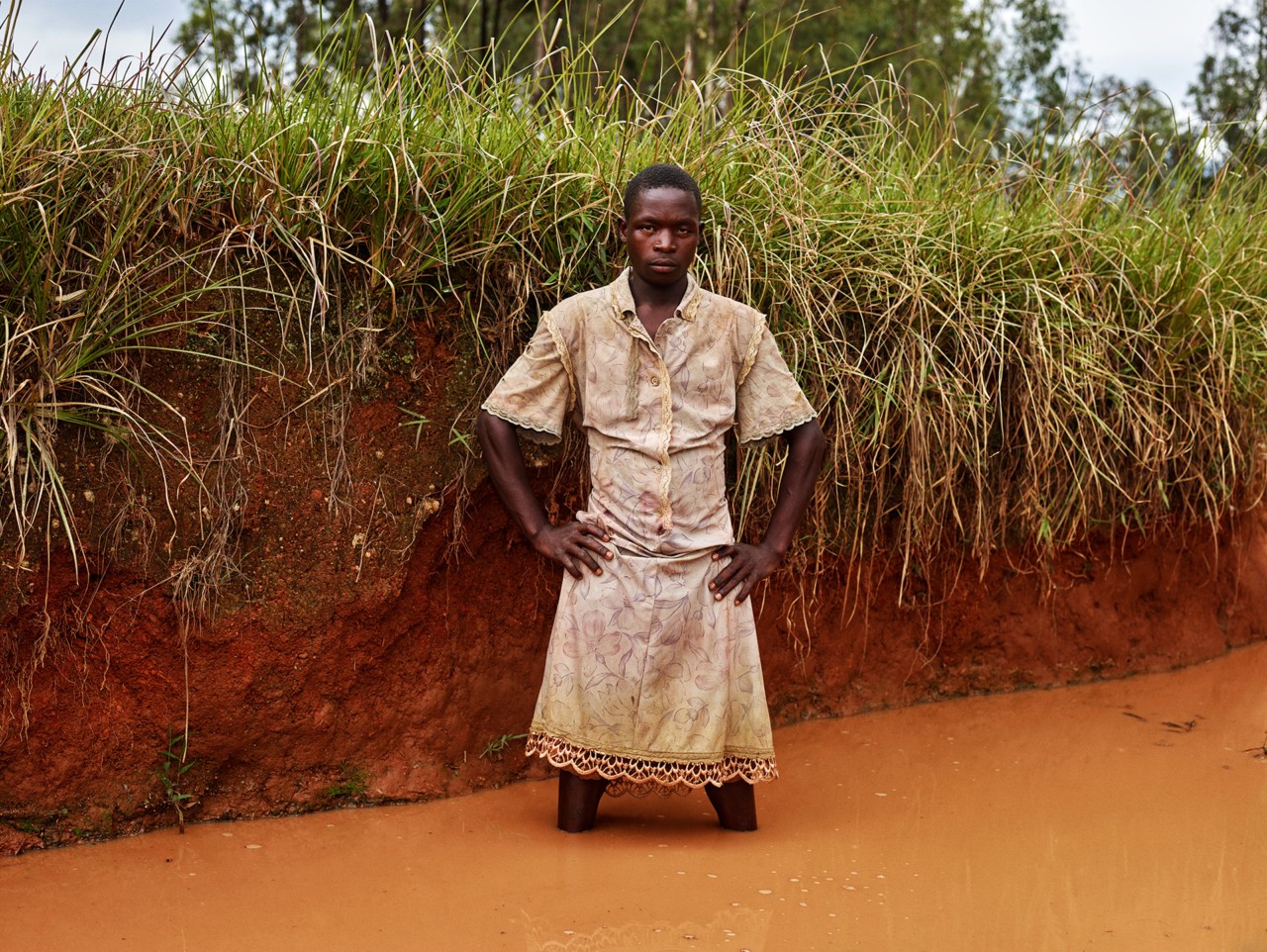 Child standing in river by Pieter Hugo