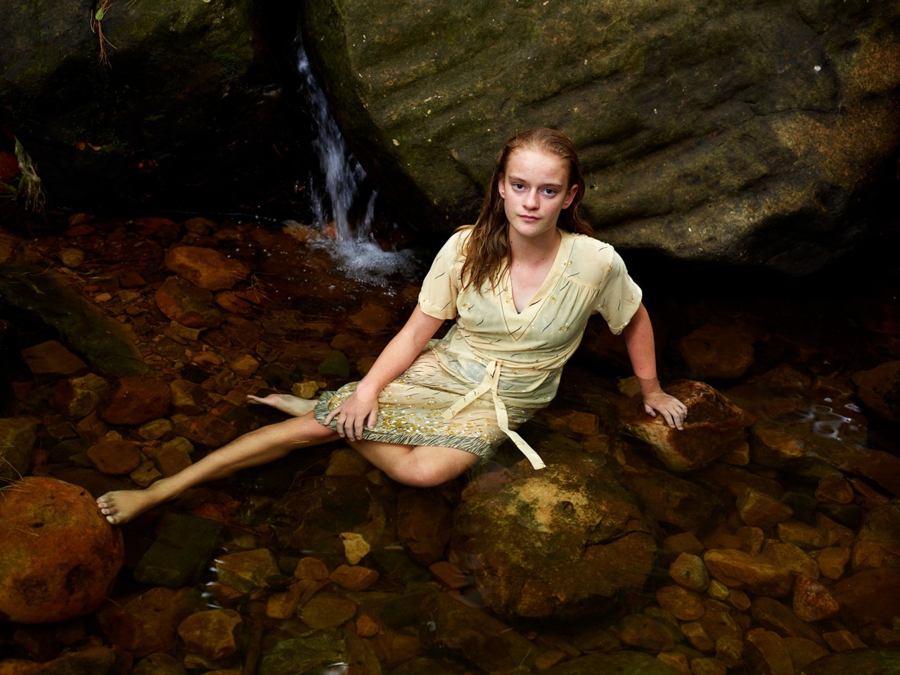 Child laying down in forest by Pieter Hugo
