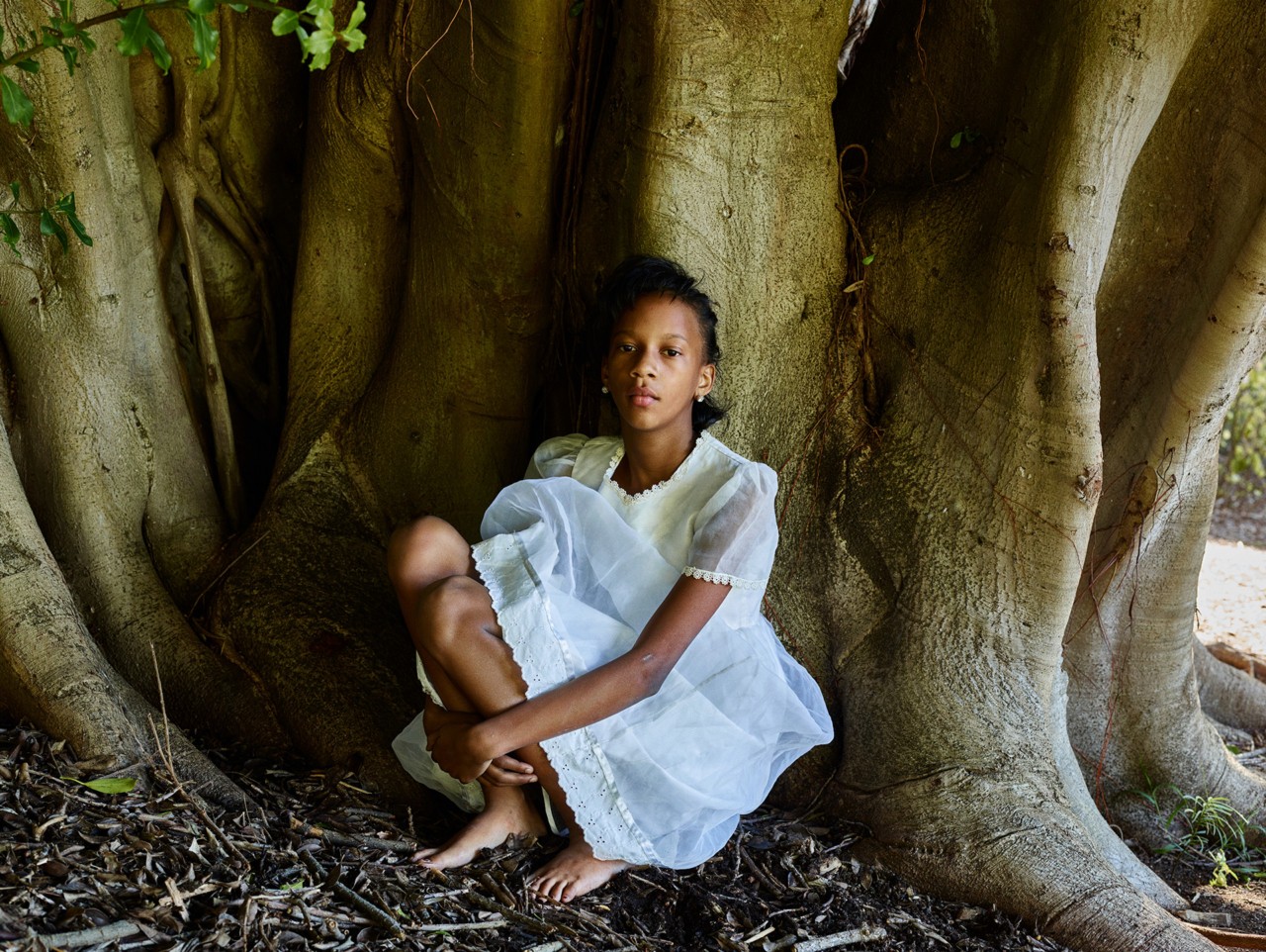 Child sitting against tree by Pieter Hugo