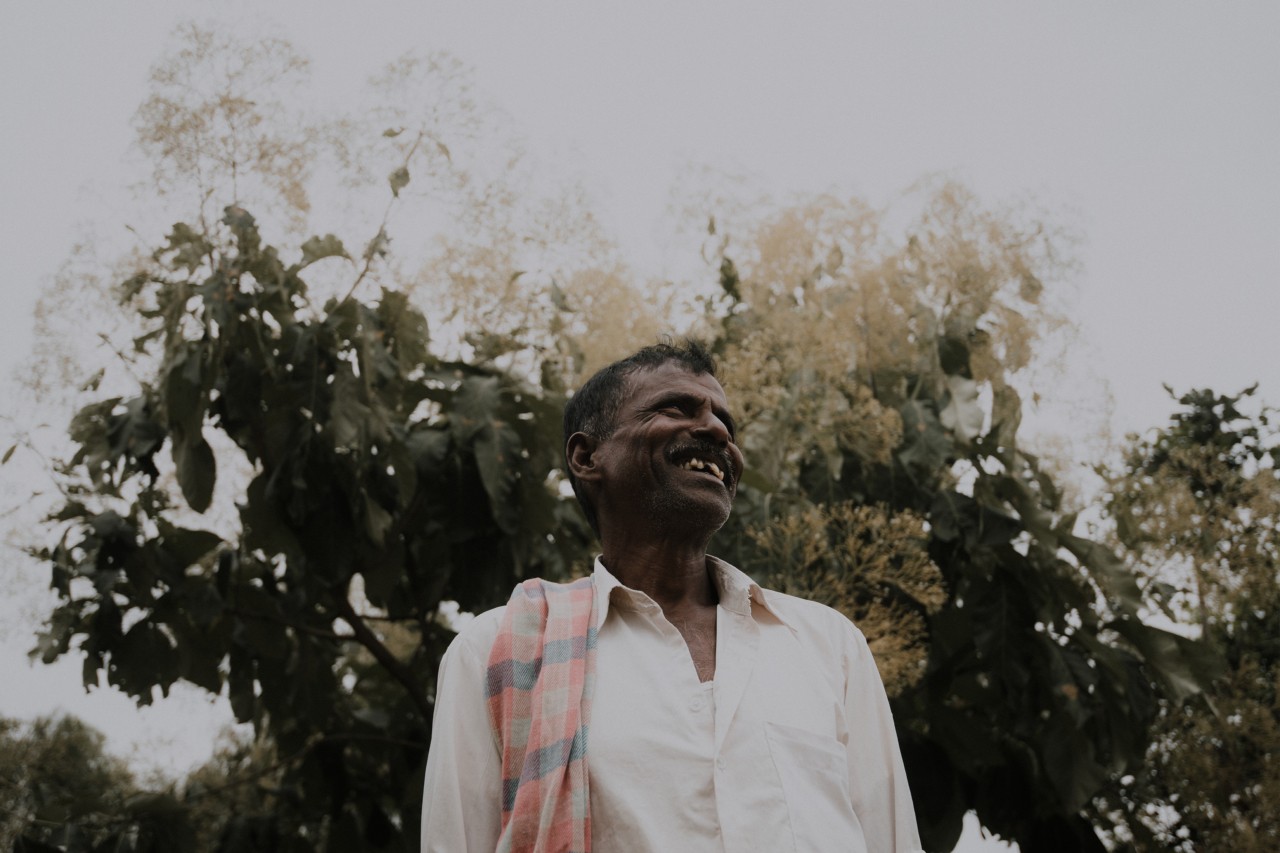 Man smiling in a field by Rishabh Malik