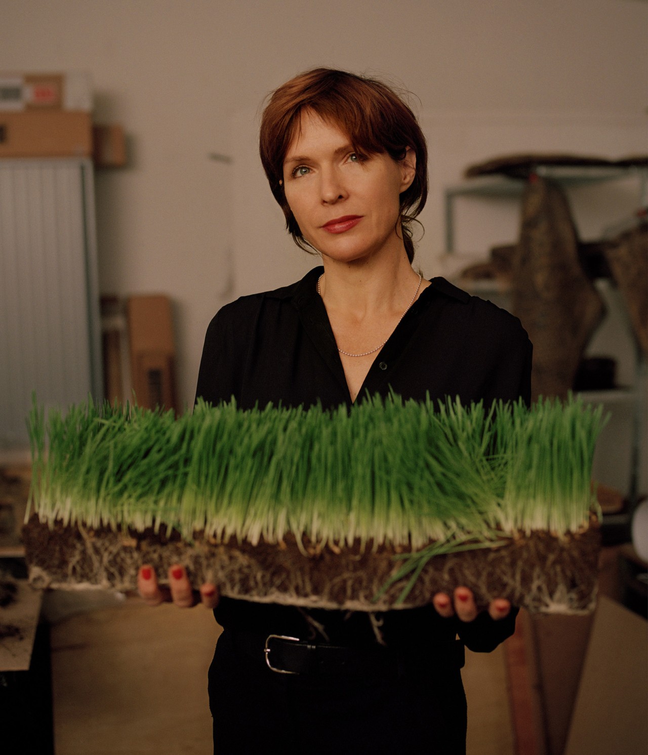 Diana Scherer holding grass in her Amsterdam studio by Bastian Achard
