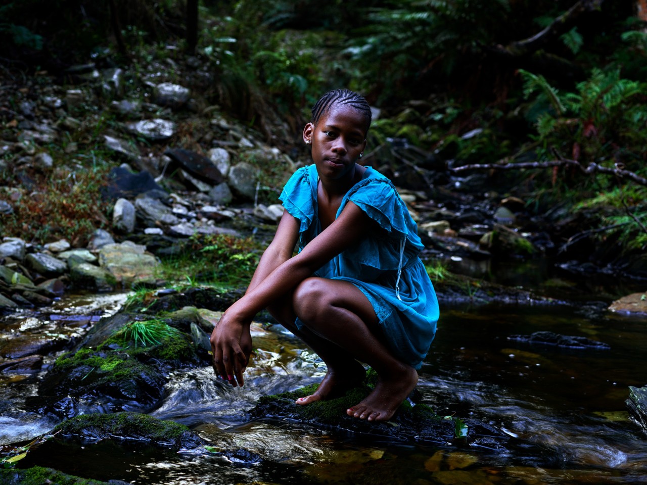 Young girl standing in river by Pieter Hugo