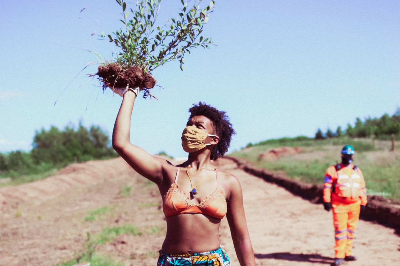 Woman holding plant at HOAC to protest HS2 line by Talia Woodin