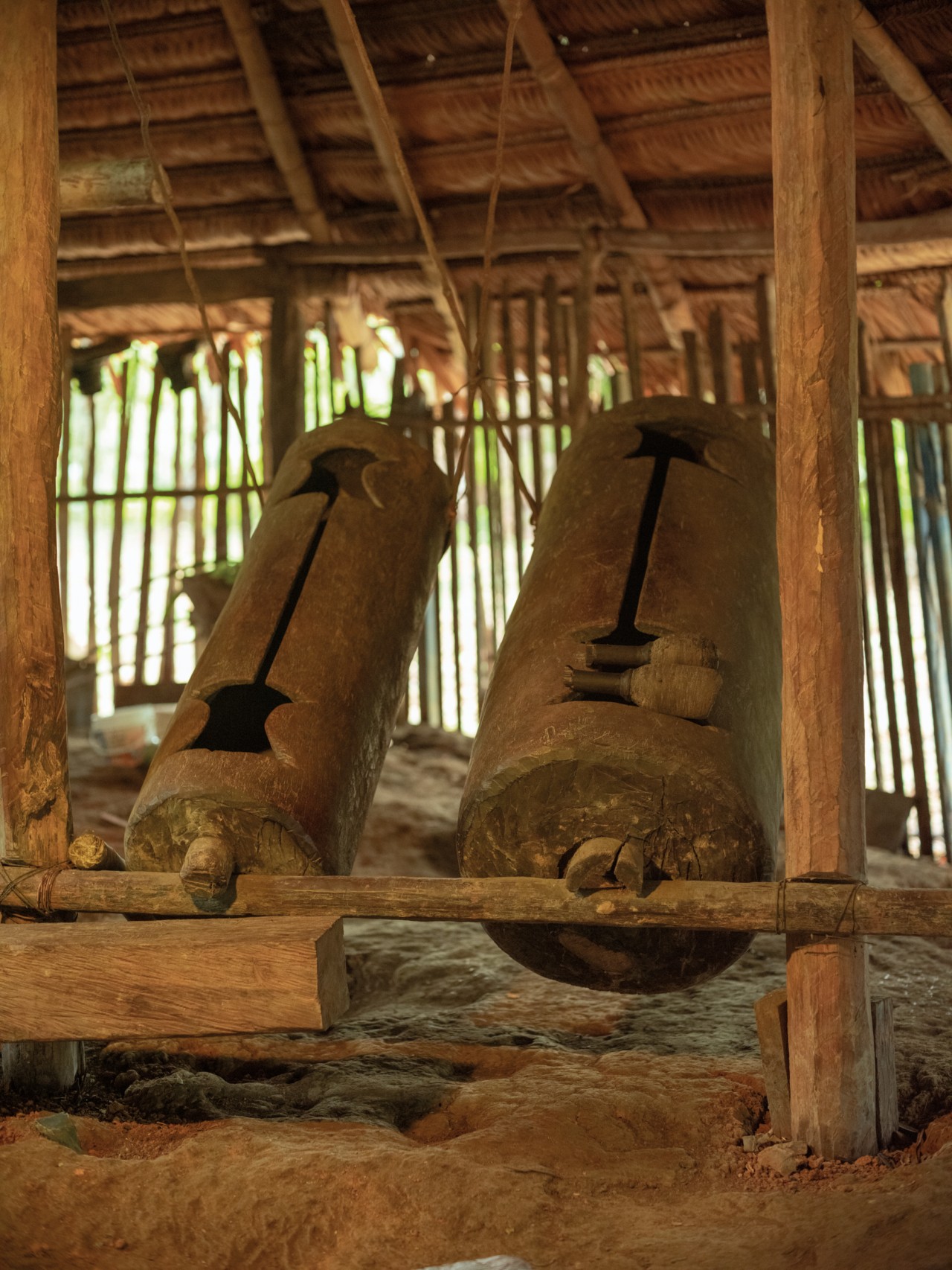 Two large brown drums inside Amazon rainforest shelter.