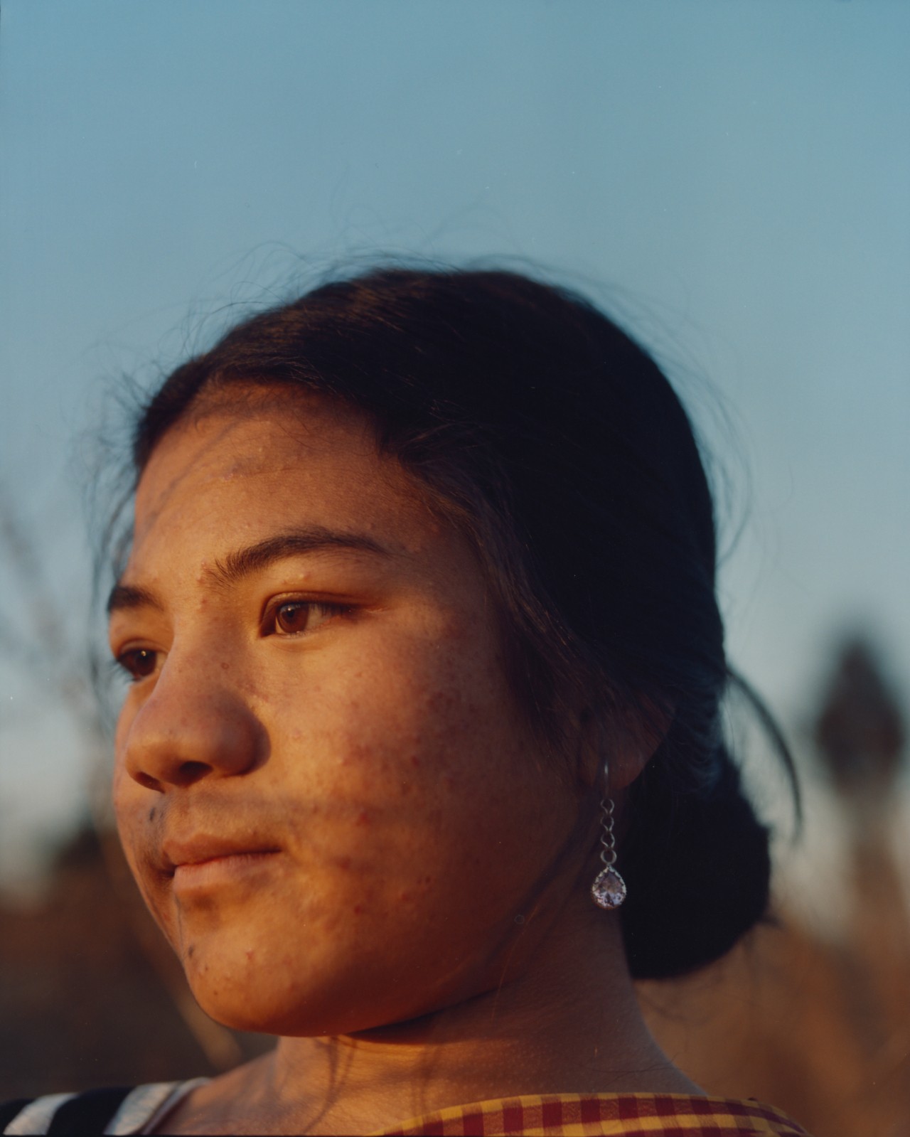 A young woman looks away from the camera.