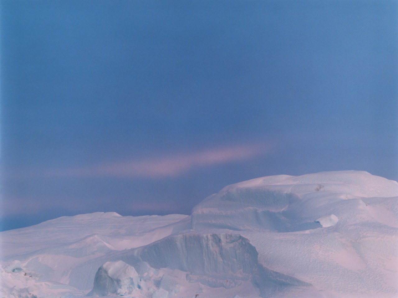 A large greenland glacier in front of purple sky