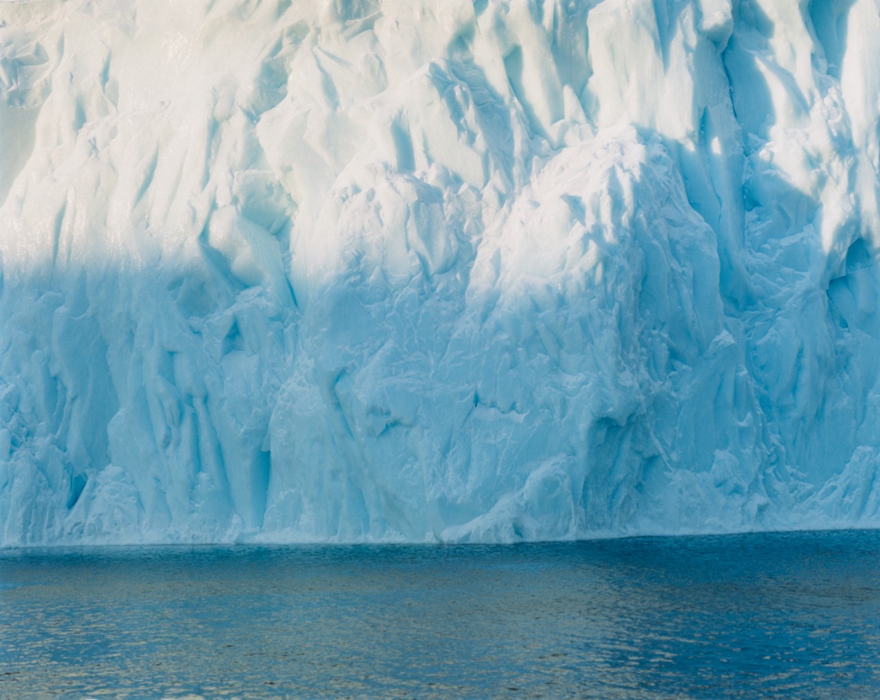 A large greenland glacier sits in the water