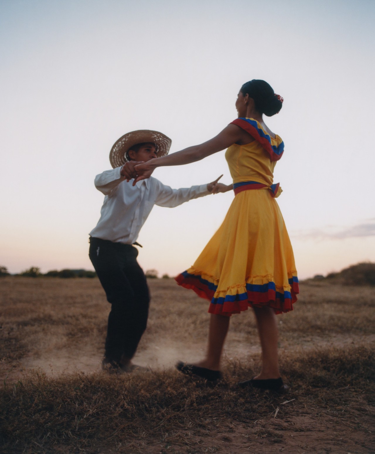 A Venezuelan woman dances with a young boy.