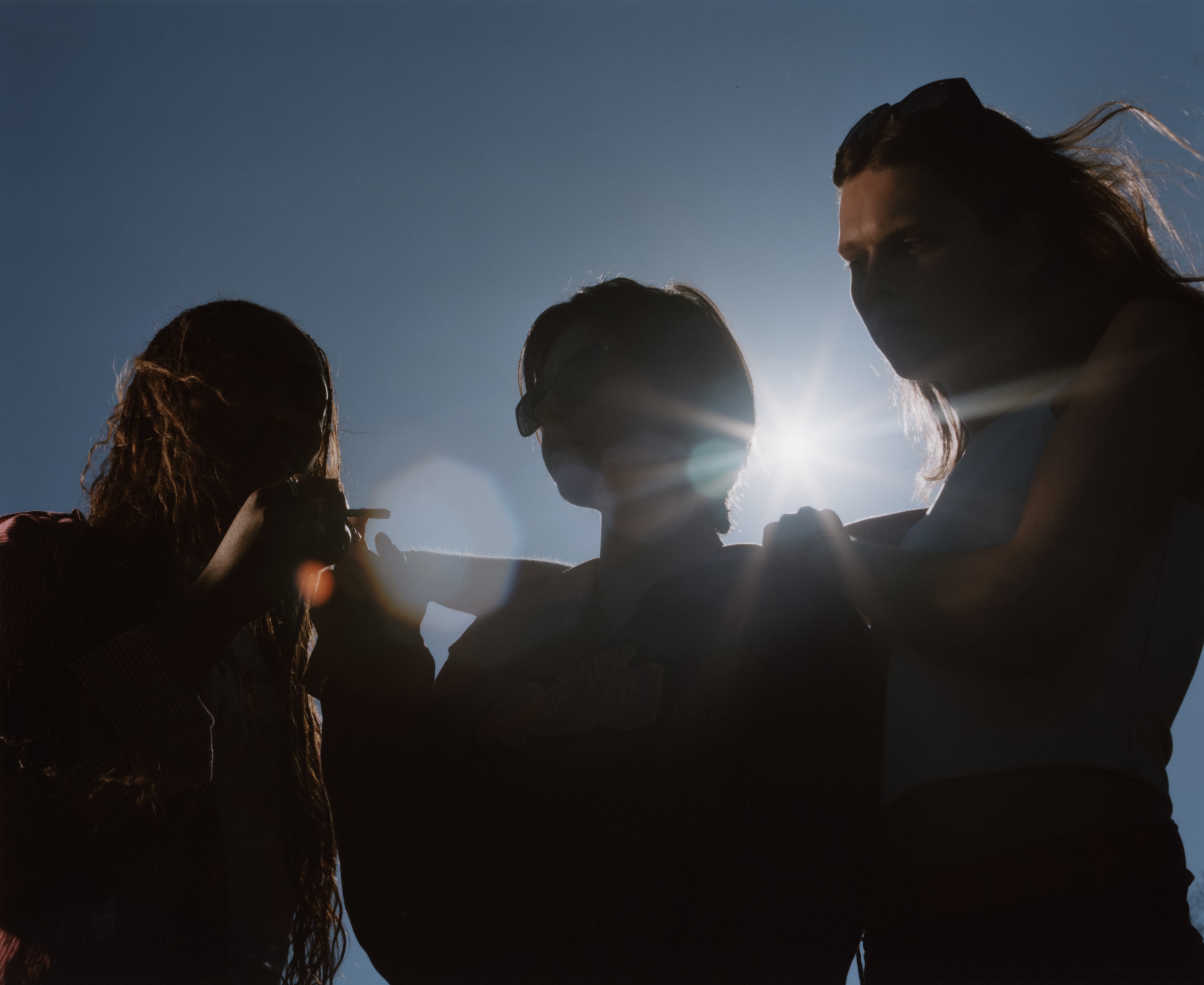 Shadow silhouettes of three teenagers smoking outside