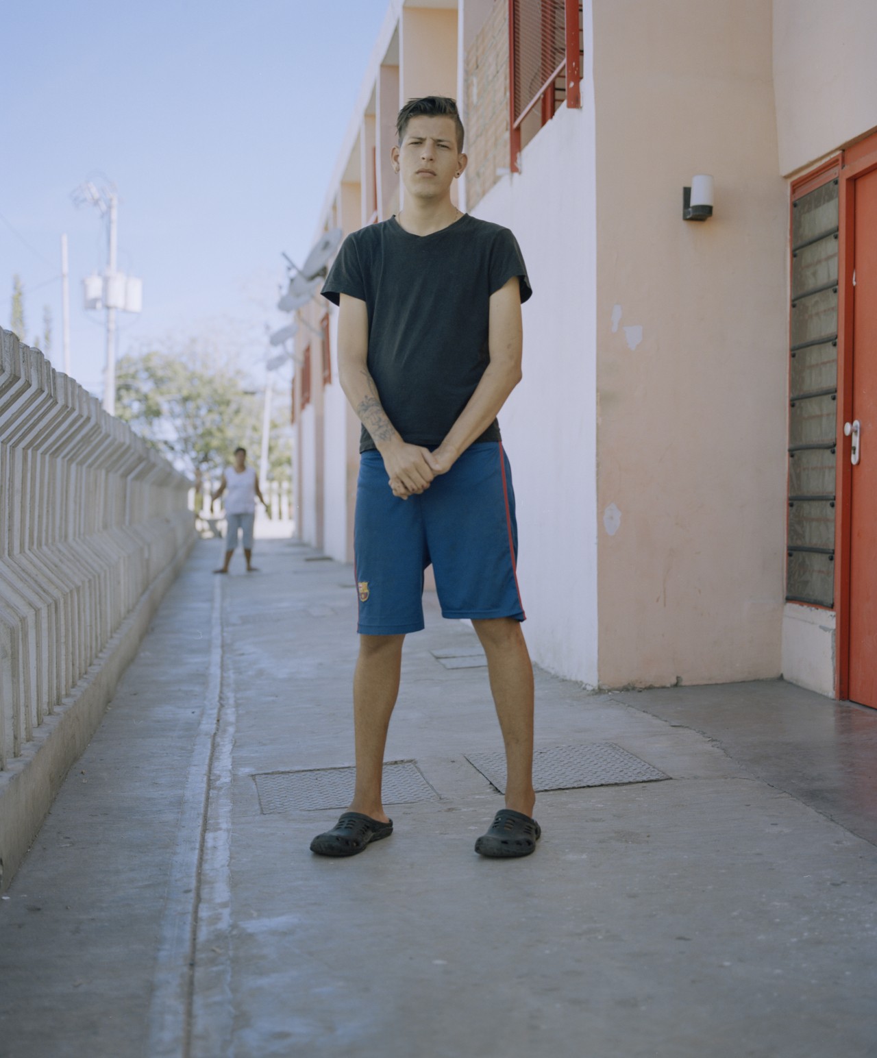 A man from Venezuela stands on the side of a building.
