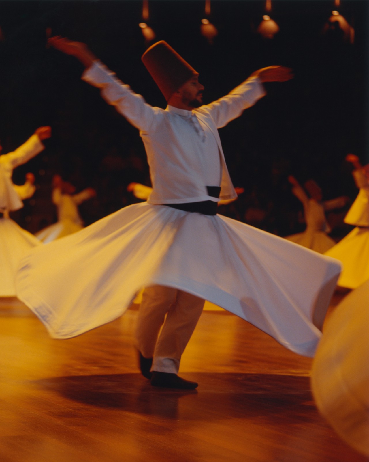 A whirling dervish dressed in a white dress engages in the sema ritual by dancing