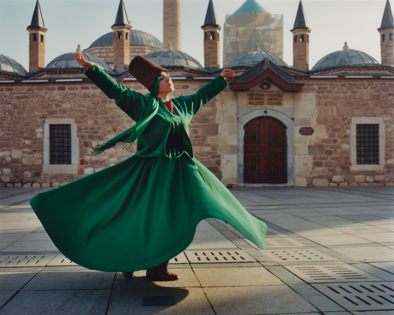 Woman in green dress engages in the ritual of sema