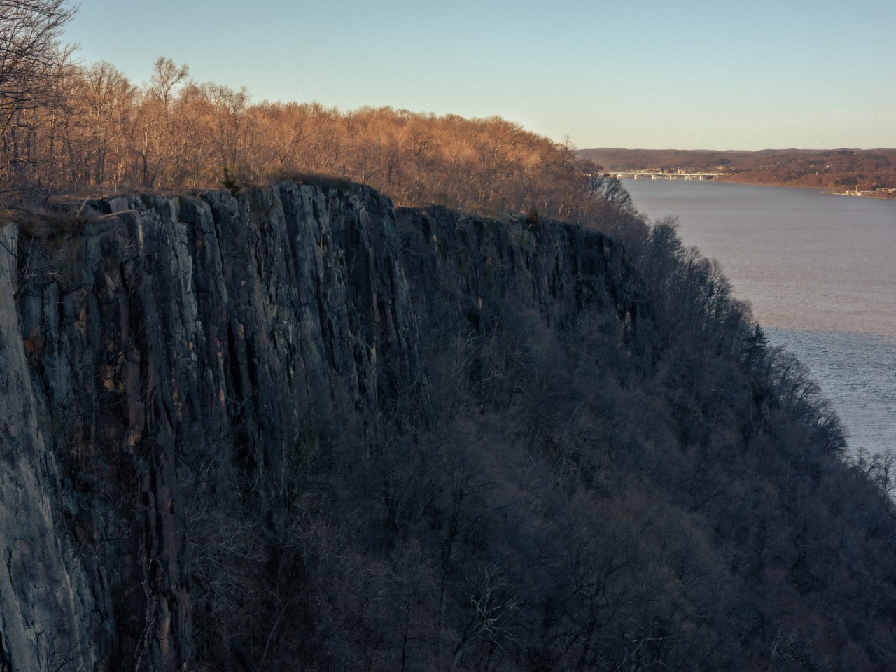 The landscape of a cliff with the ocean in the distance.