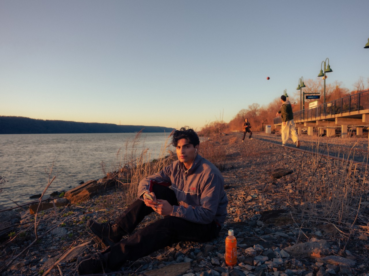 Young Asian American man sitting on the shoreline