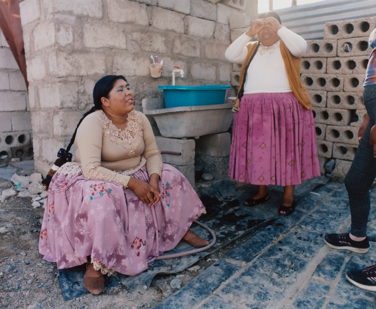 Lourdes Gutiérrez sitting down, wearing lilac polleras.