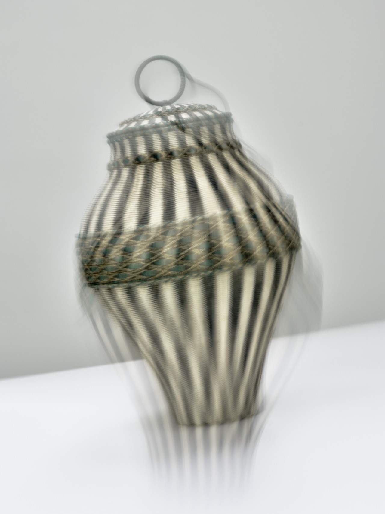 A blurry off center shot of a black, beige, and green basket.