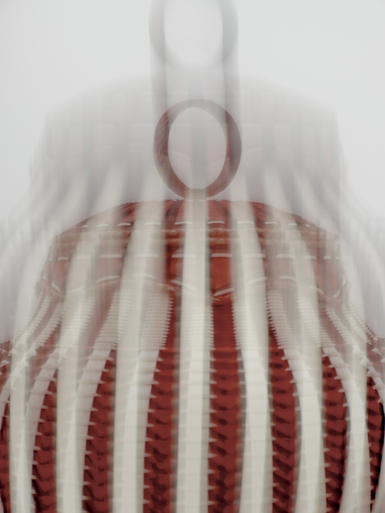 A blurry close up shot of a red and beige basket.