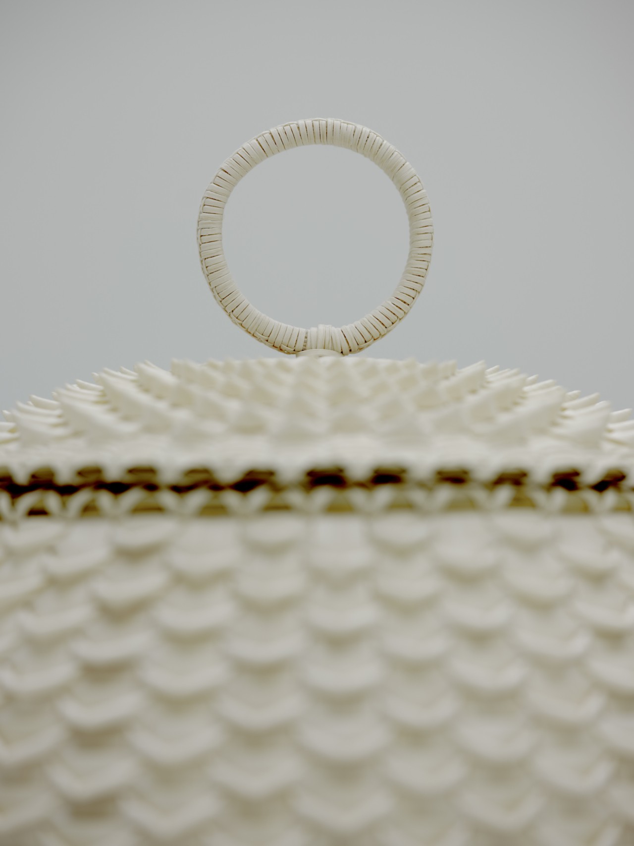 The top of a white basket has a small circle attached.