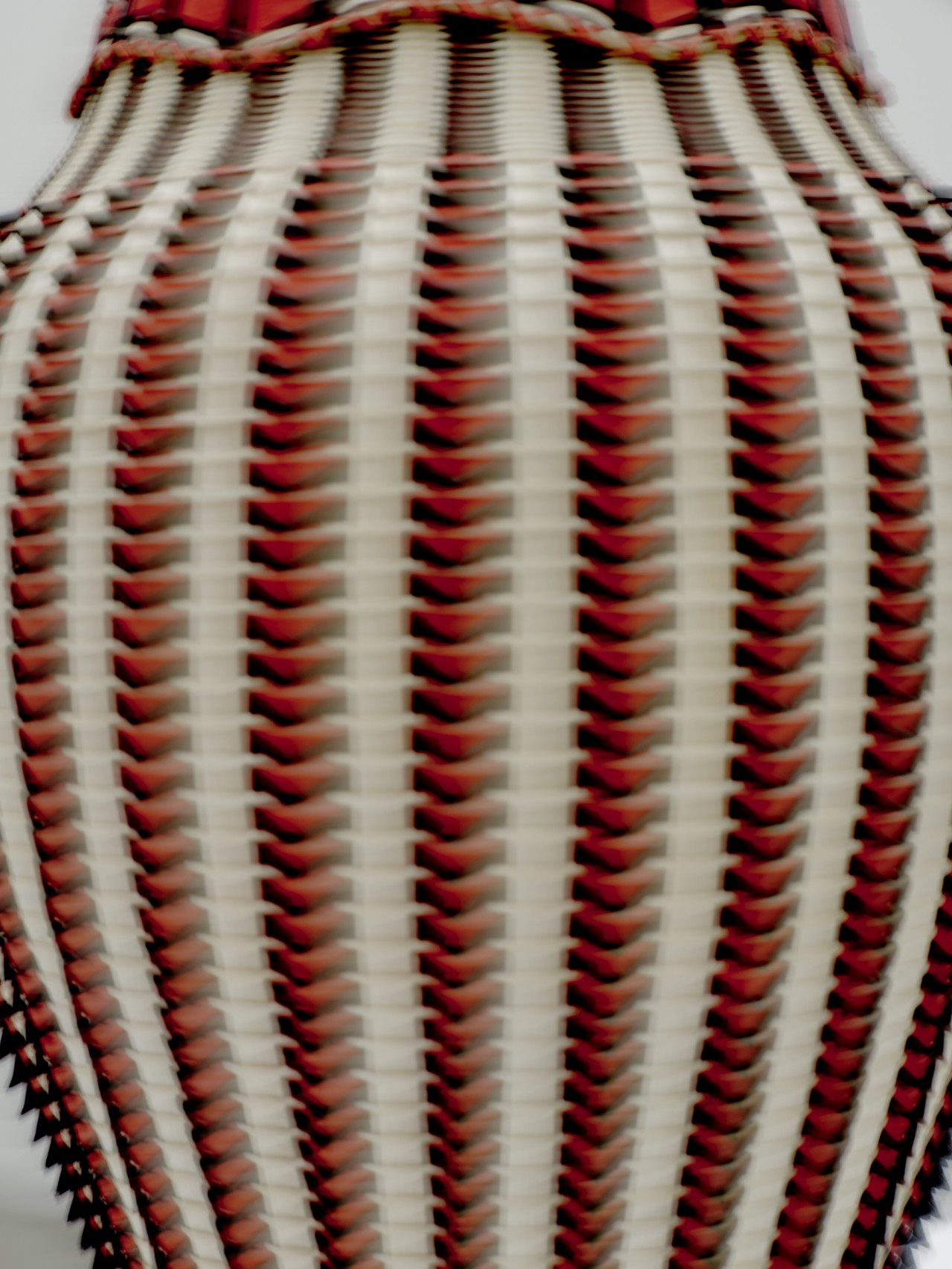 A close up of a red, beige, and black basket.