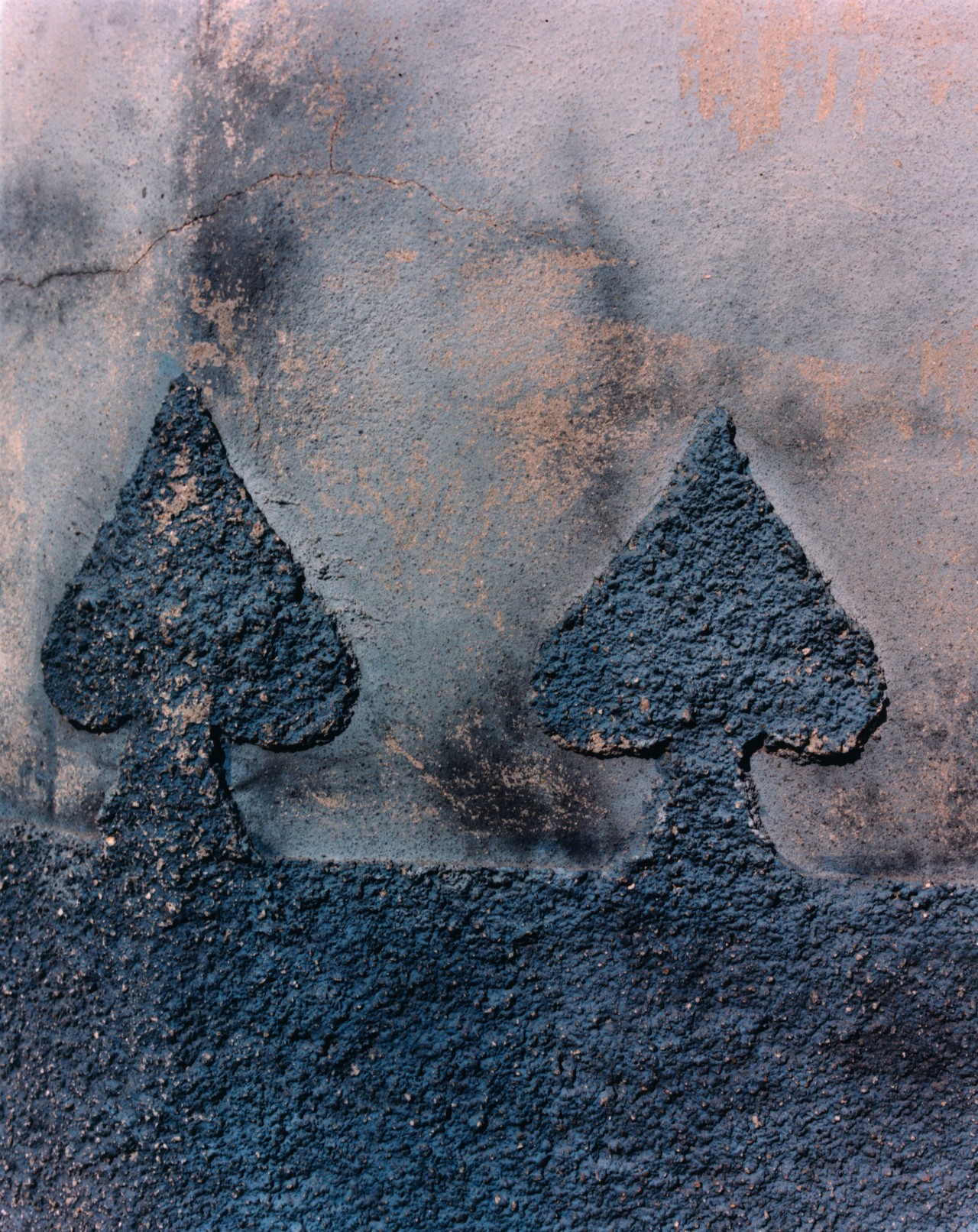 Two black spade symbols are carved along a wall ion Cuba.