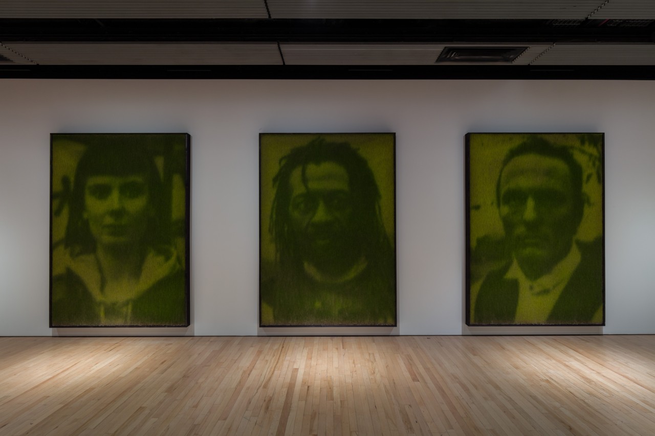 Three large portraits hang on the wall at the Hayward Gallery.
