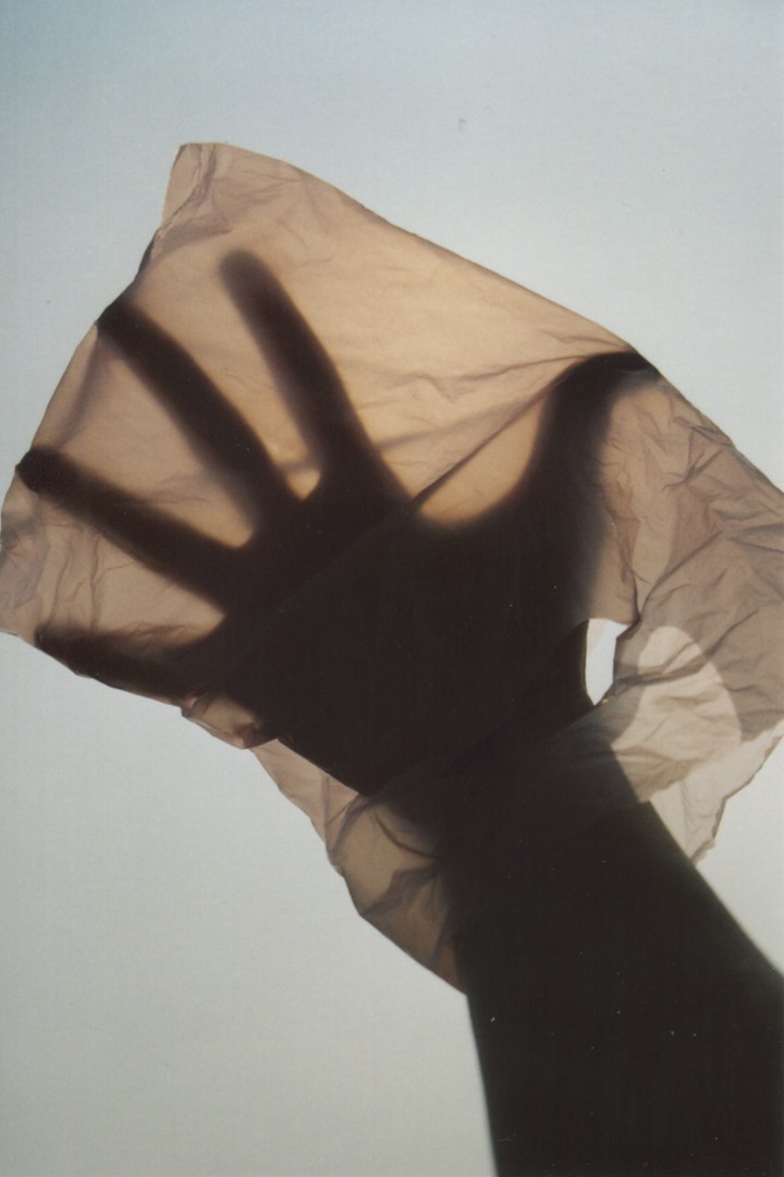 A human spreads their hand inside a plastic bag.