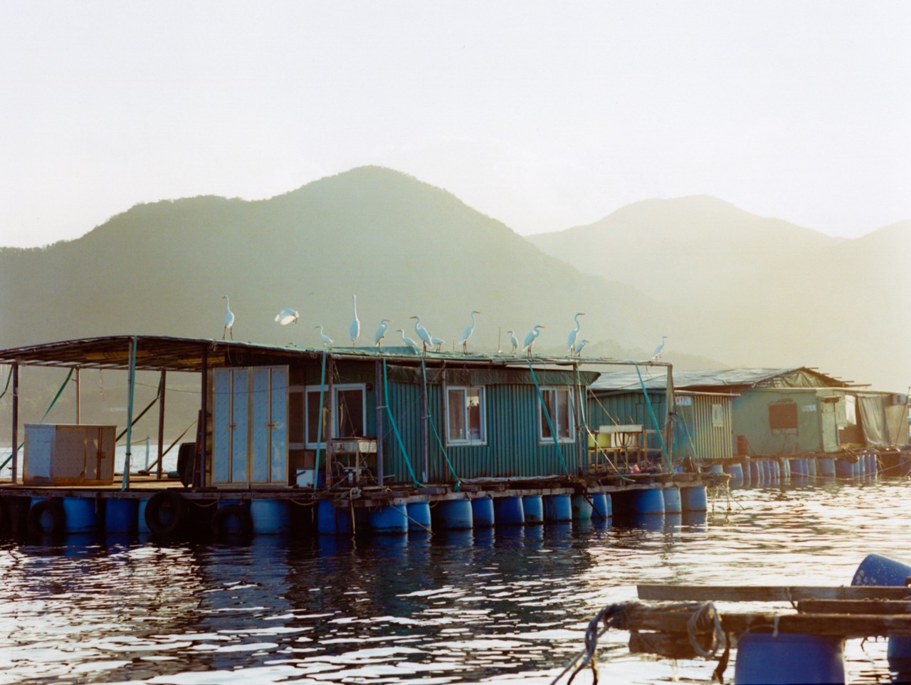 A small house in a Hong King village sits on the water.