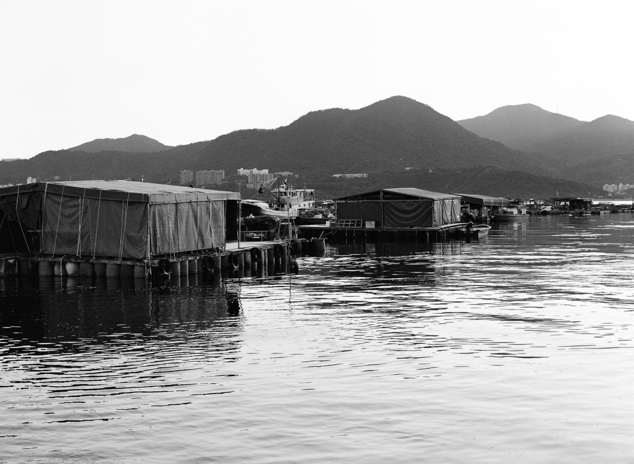 Several shacks sit on top of the water in a Hong Kong village.