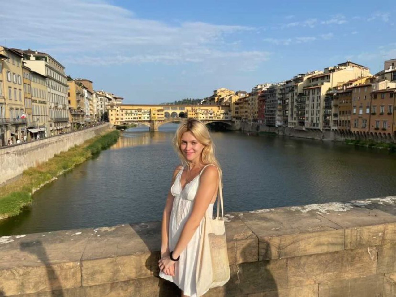 Anna Conkling standing on a bridge in front of the water.
