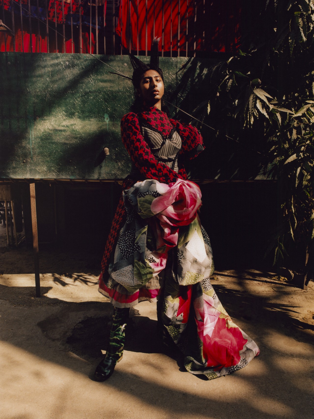 A model wearing a large red garment dress poses outside in Delhi.