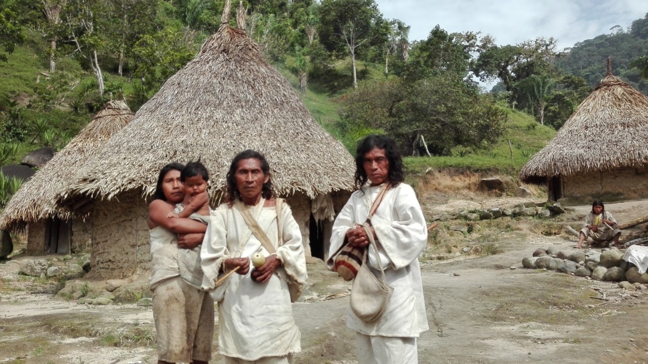 Kogi people stand in front of their village.