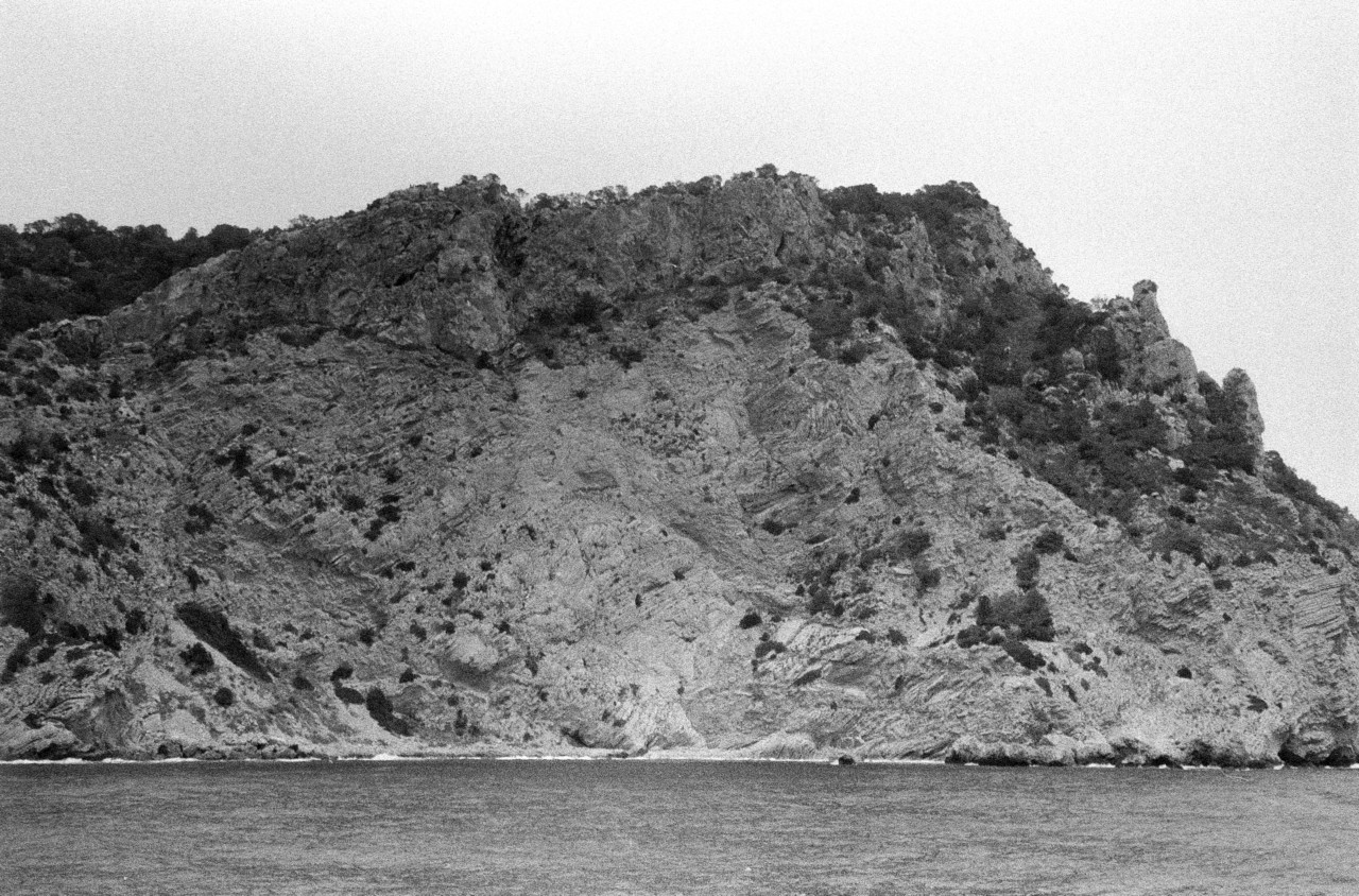 A large cliff sits in the middle of the Spanish sea.