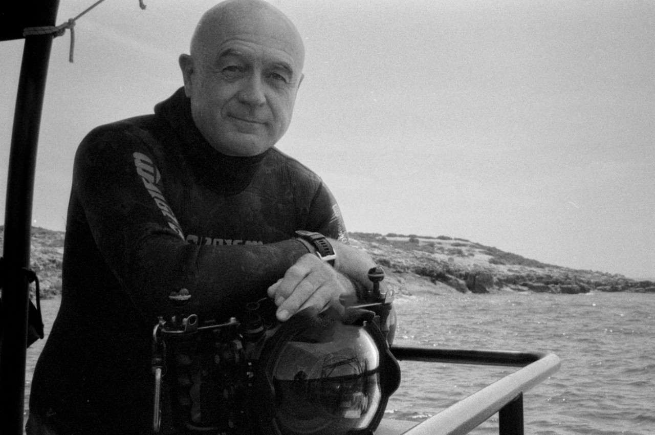 A diver poses on a boat sailing a sea in Spain.