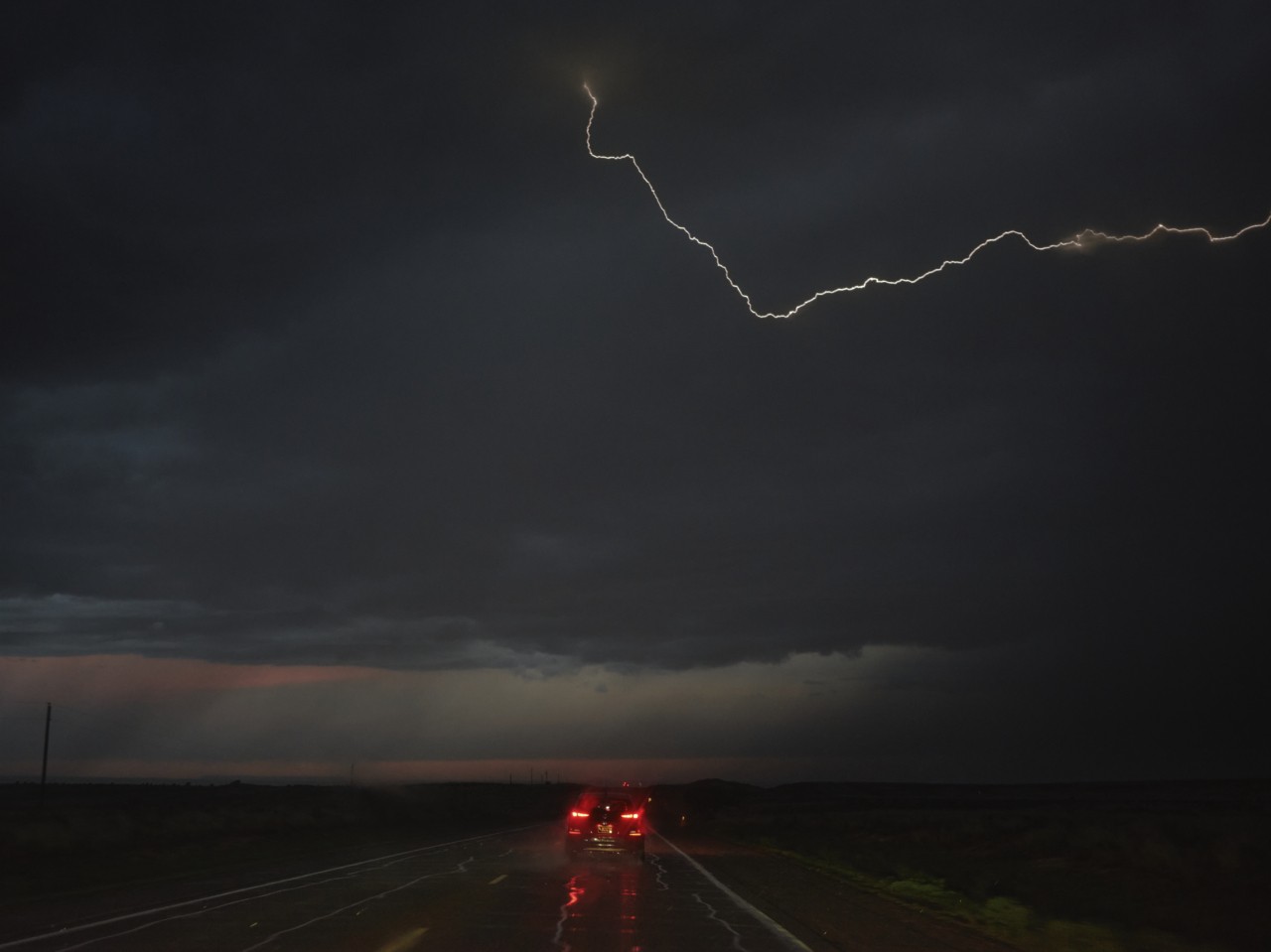 Lighting strikes as a car drives to Tucumcari, NM from Dalhart, TX