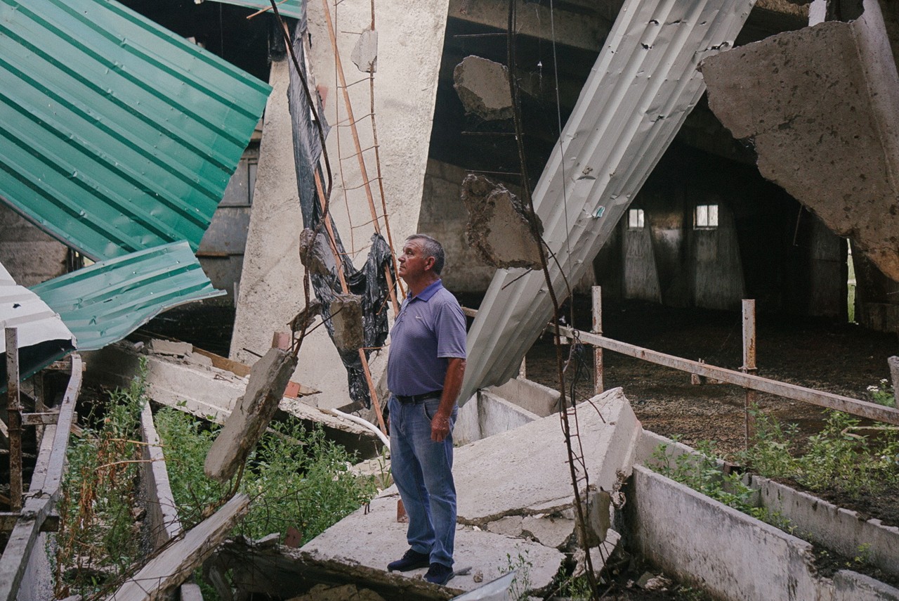 On the rubble of a building, a Ukrainian stands where his animals once lived.