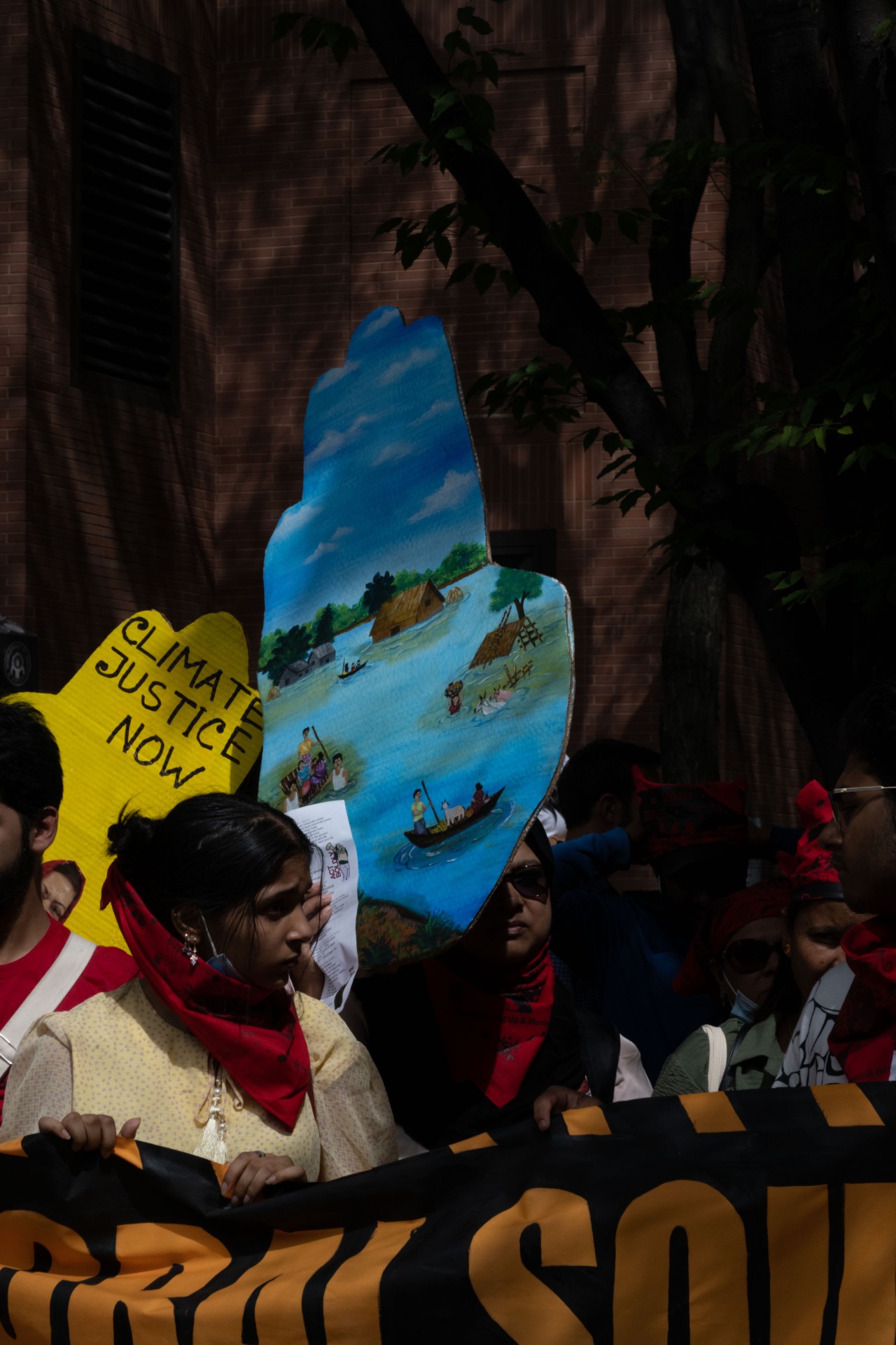 Protesters stand together holding signs calling for a response to climate change.
