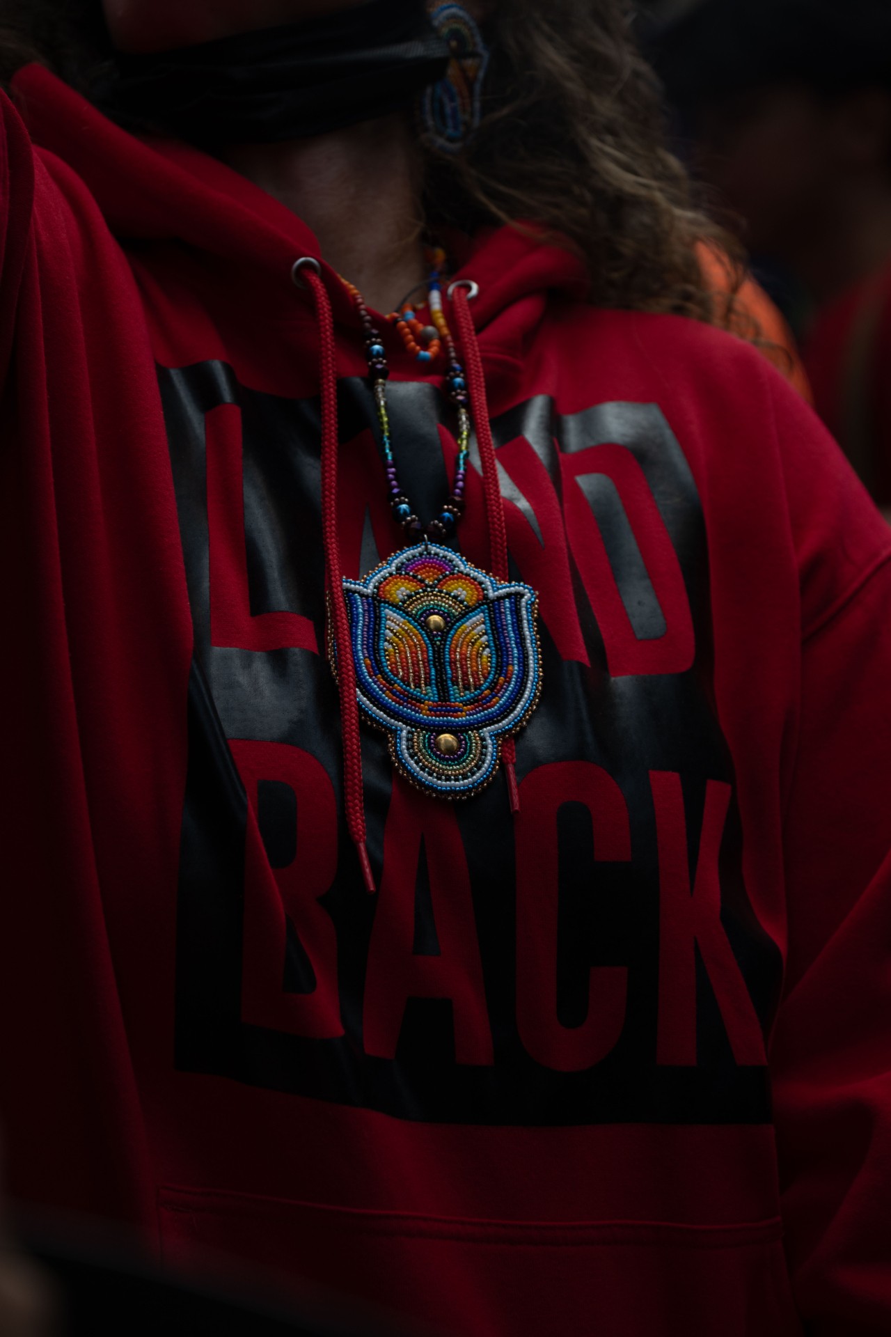 A protestor wearing as red and black sweatshirt with the words 