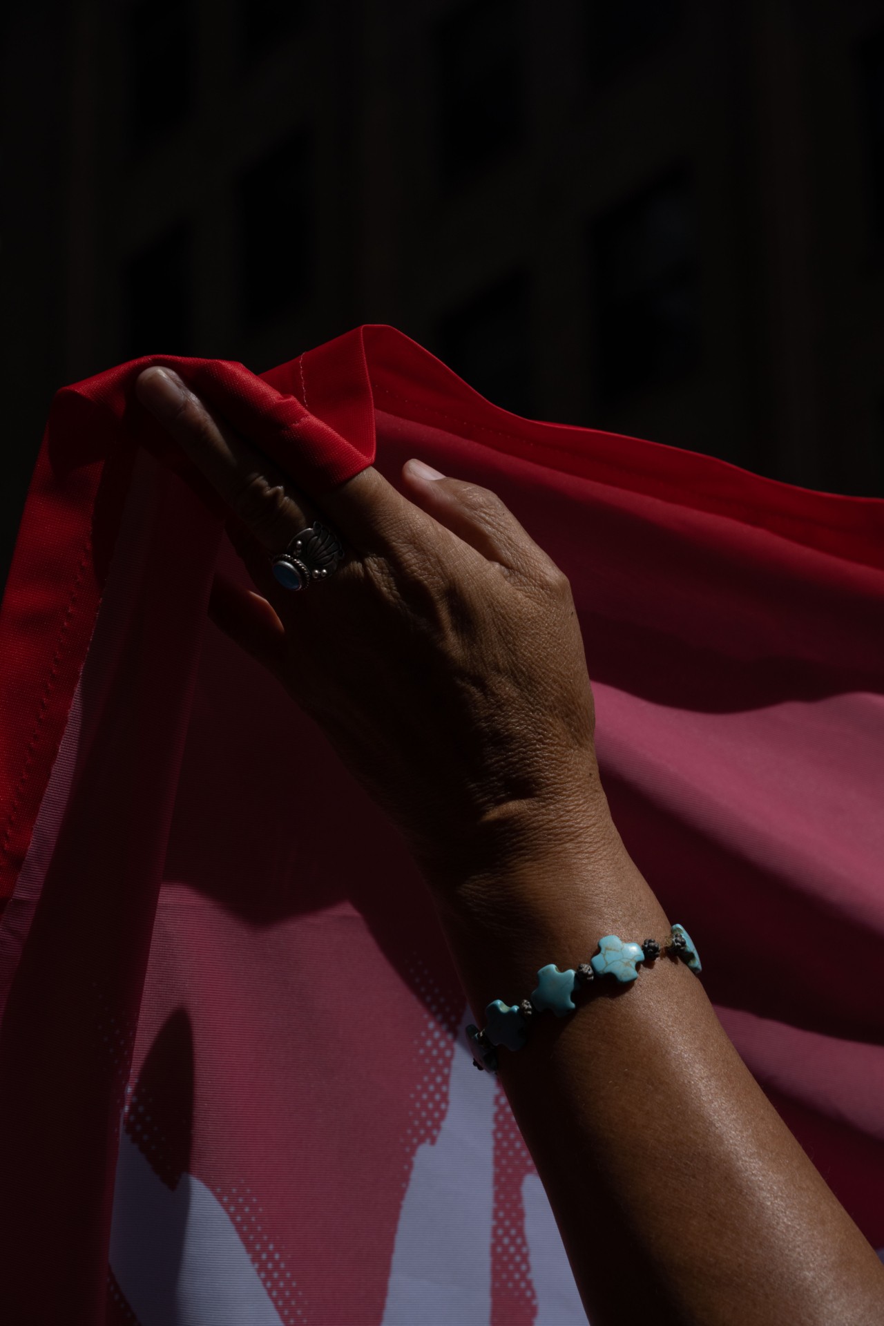 A person's hand is shown raising a red flag.